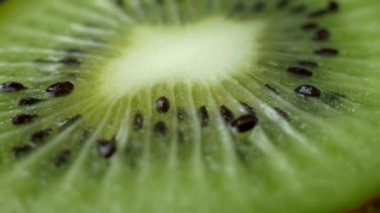 Makro shot dilimlenmiş kivi dilimi. Kesilmiş kivi diliminin dokusuna aşırı yakın çekim. Taze meyve suyu..