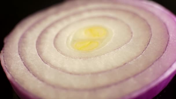 スライスした熟した紫の玉ねぎの回転スライスのマクロショット スライスされた玉ねぎのテクスチャの非常に近いクローズアップ 新鮮なジューシーな野菜 — ストック動画