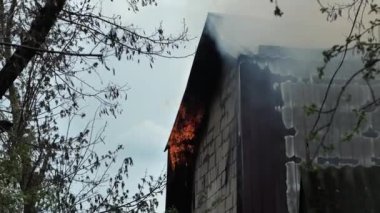 Büyük bir yangın sırasında özel bir evin çatısını yakmak. İtfaiyeciler yangın sırasında yangın hortumlarından çıkan suyla alevlere karşı savaşır..