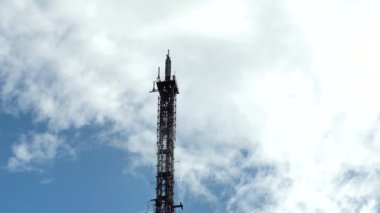 Zaman ayarlı video. Hızlı hareket eden bulutların arka planında mobil anten var. 3G, LTE, 4G ve 5G cep telefonu ve mobil sinyal yineleyicili büyük TV kulesi.
