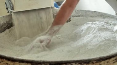 Bir fırın işçisi özel bir makineden un seçer. Hamur yoğurma ve fırın ürünleri hazırlama