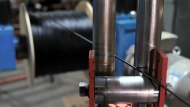 Optik kabloyu üretim hattındaki bobbin kutusuna sarmak. Kablolu yayın. Kablo fabrikası. Siyah kabloyu makaraya sarmak. İnternet kablosu üretim fabrikasında üretim hattı