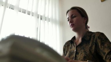 Bir kadın ofis çalışanı cep telefonuna bağlanıp telefona cevap veriyor. Sekreter telefonlara bakar. Çağrı merkezi çalışanı ya da resepsiyonist telefonda konuşuyor..