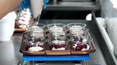 Şekerci tatlıya krema ve reçel koyar, mutfak terazisinde tartılır..