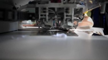 Elbiselerin ceplerini dikmek için özel bir dikiş makinesinin yakın çekimi. Tekstil üretimi, giyim fabrikası.