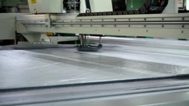 Kumaşlar için otomatik kesim kompleksi kullanarak kumaşları kalıplara göre kesmek. Üretim fabrikasında kıyafet yapıyorum. Tekstil endüstrisi.