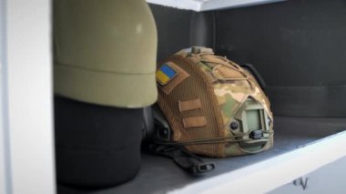 Ukrayna silahlı kuvvetlerinin Ukrayna bayrağı şeklinde bir sembolü olan taktik miğferi. Kışladaki bir dolapta askeri mühimmat var. Ukrayna askeri üniforması