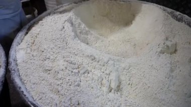 Aşçı kovayla un toplar. Bir fırıncı fırında ekmek pişirmek için hamur yoğurur..