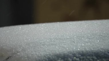 Bir kış akşamı bir sokak lambasının ışığı altında yüzeye kar yağar. Kar yağışıweather condition.