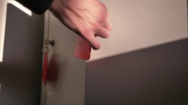 Bir süpermarkette, bankada, spor salonunda erkek bir ziyaretçinin eşyalarını koyduğu ve kapılarını 8 numaralı anahtarla kapattığı dolaplar..