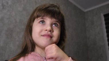 Küçük kız onun hakkında düşündü ve sonra bu fikre hevesle yanıt verdi. Anaokulundan bir çocuk bir şey buldu. Kız bir şeyler düşünüyor.