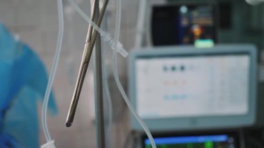 Klinikteki bir cerrahi operasyon sırasında ameliyat makası ya da kalp monitörünün arka planına klemp yakın çekim. Hastanede resüsitasyon.