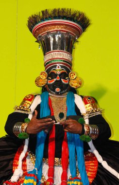 MUNNAR, INDIA - 10 Şubat 2016: Kathakali, Hindistan 'da Kerala eyaleti Munnar' da kafasına büyük şapka takmış Siyah Geleneksel Giyimli Dansçı.