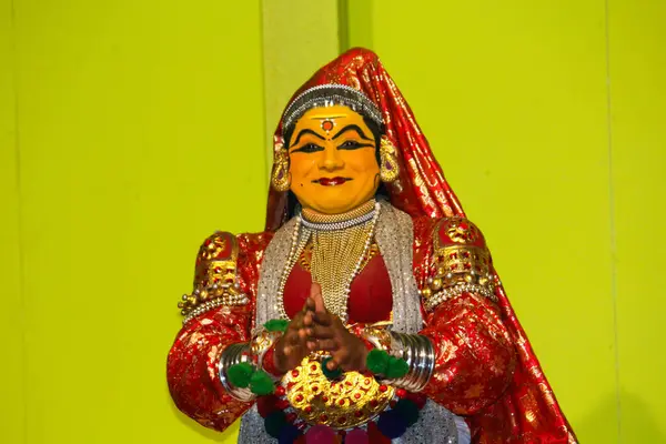 MUNNAR, Hindistan - 10 Şubat 2016: Kathakali dansçısı renkli kıyafetler giyiyor, Hindistan 'da Kerala eyaletinin Munnar şehrinde süsler takıyor. Punarjani Geleneksel Köy Munnar