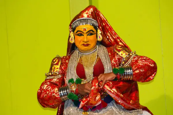 MUNNAR, INDIA - 10 Şubat 2016: Kathakali dansçısı Hindistan 'da Kerala eyaletinde Munnar' da kumaş parçasını katlıyor ve sıkılaştırıyor. Punarjani Geleneksel Köy Munnar