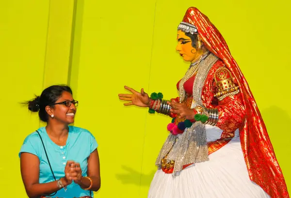 MUNNAR, INDIA - 10 Şubat 2016: Kathakali dansçısı, Hindistan 'ın Kerala eyaletinde Munnar' da kadın izleyiciyle birlikte sahne alıyor. Punarjani Geleneksel Köy Munnar