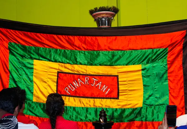 MUNNAR, INDIA - 10 Şubat 2016: Kathakali dansçısı sarı, yeşil ve kırmızı kumaşın arkasında ve Hindistan 'da Kerala eyaletinin Munnar kentindeki gösteriyi izleyen izleyici.