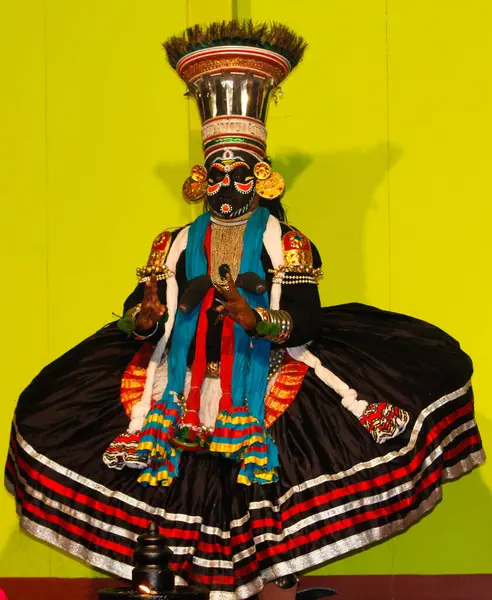 MUNNAR, INDIA - 10 Şubat 2016: Kathakali, Hindistan 'da Kerala eyaletinin Munnar şehrinde geleneksel siyah elbiseli bir dansçı. Lamba ile tam görünüm.