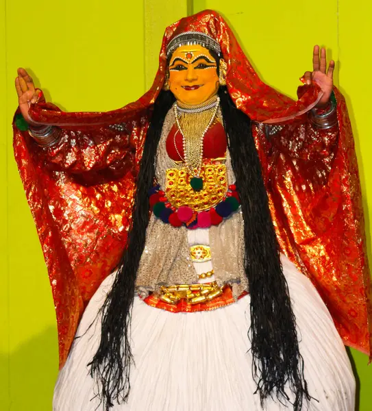 MUNNAR, Hindistan - 10 Şubat 2016: Kathakali, Hindistan 'da Kerala eyaletinin Munnar şehrinde Kırmızı ve Beyaz Geleneksel Giysiler içinde dans ediyor. Sanatçının uzun siyah saçları var.