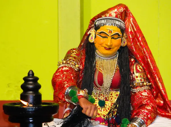 MUNNAR, INDIA - 10 Şubat 2016: Kırmızı ve Beyaz Geleneksel Giyinik Tanımlanamayan Sanatçı / Kathakali Hindistan 'ın Kerala eyaletinde Munnar' da lambayı yakıyor.
