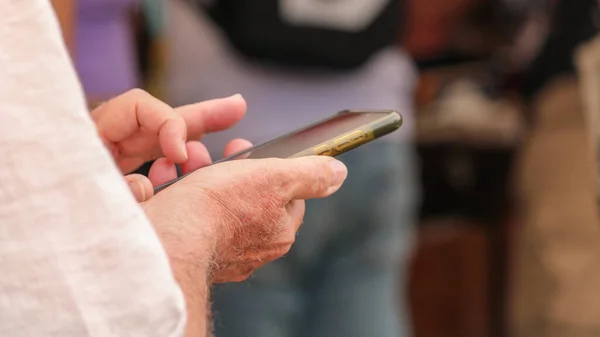 Cep telefonu kullanan bir adamın ellerinin ayrıntıları