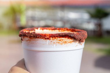 Bir bardak köpüklü biberli Michelada birası.