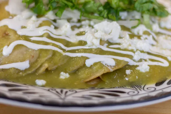 Meksika yemek tabağına yakın çekim. Yeşil soslu enchilada.