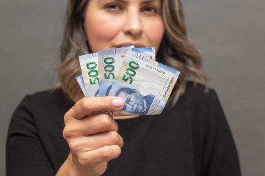 500 Meksika pezosu gösteren bir kadın. Ekonomi kavramı. para