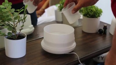 Adam hazırlanıyor ve nemlendiriciyi suyla ve kokusuyla açıyor. aromaterapi