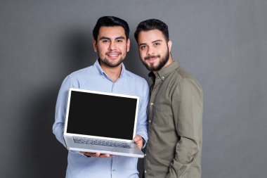 two hispanic businessmen showing laptop screen