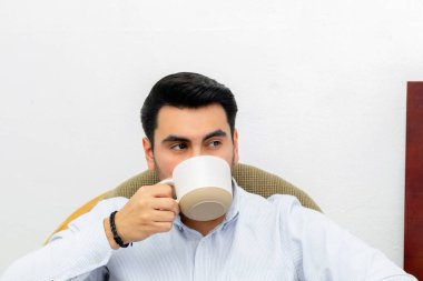handsome latino young man drinking coffee. business man holding cup