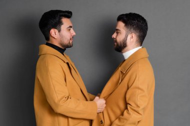 Stüdyoda çok ırklı eşcinsel çift şık giyiniyor. İki erkek model.