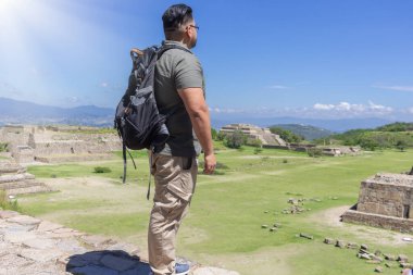 Gezgin adam Oaxaca, Meksika 'daki Monte Alban arkeolojik bölgesindeki piramitleri inceliyor. turist