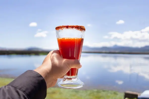 Michelada 'yı buzlu camda tutan el. Açık hava birası
