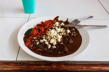 Chorizo ve peynirli siyah enchiladas, Oaxaca 'da geleneksel Meksika yemeği. enmoladas