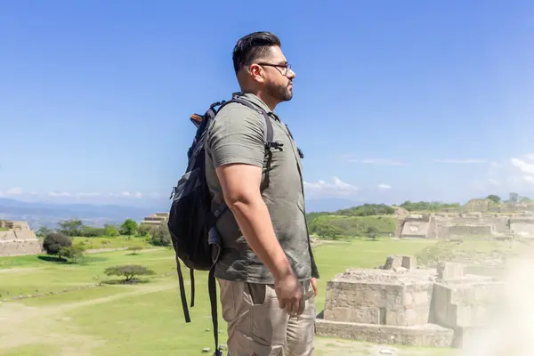 Traveler man in profile standing on pyramid of Monte Alban in Oaxaca Mexico