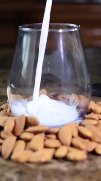 Mandelmjölk Som Faller Slow Motion Ett Glas Omgivet Organiska Mandlar — Stockvideo