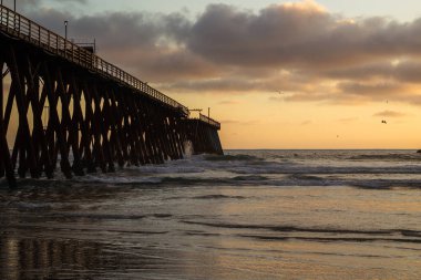 landscape at sunset in the sea of rosarito mexico with view of the sea and the pier clipart