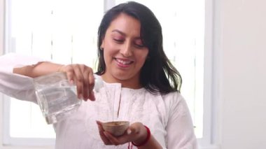 Mutlu Meksikalı kadın jicara kasesine mezcal veya gümüş tekila dolduruyor.