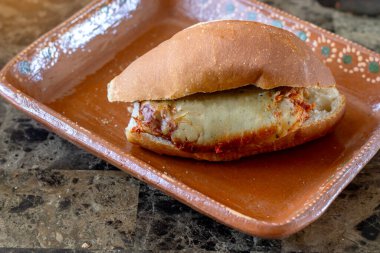 Geleneksel Meksika turtası tamale ve salsa ile dolu, kırsal bir çömlek tabağında dinleniyor, otantik Meksika mutfağı sergileniyor.