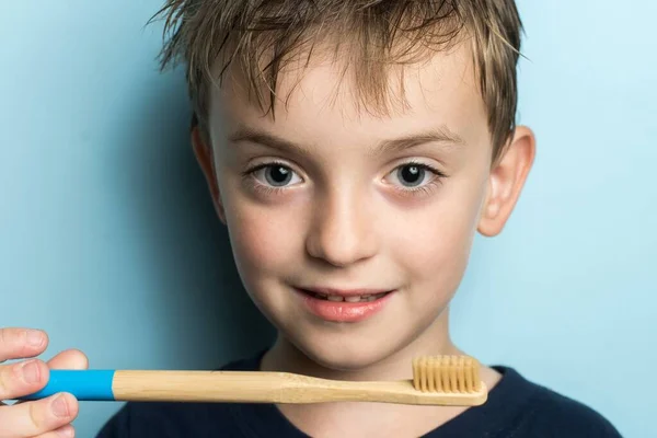 Chłopiec Trzyma Rękach Bambusową Szczoteczkę Zębów Przyjazne Środowisku — Zdjęcie stockowe