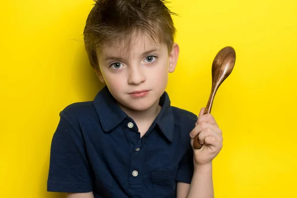 Chłopiec Europejskim Wyglądzie Trzyma Rękach Bambusową Łyżkę Miejsce Tekst Żółte — Zdjęcie stockowe