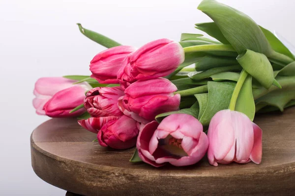 a bouquet of pink tulips on a table or chair on a white background