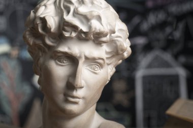 Kütüphanenin arka planında antik heykeller var.