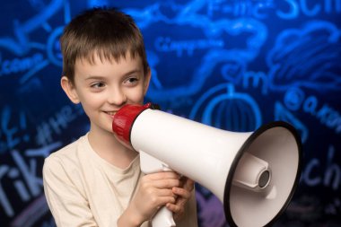 Smiling boy holding a megaphone against a school-themed chalkboard background. Perfect for communication, education, or leadership concepts, emphasizing school announcements or teamwork ideas clipart