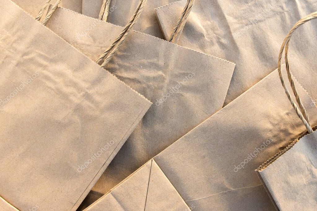 Stack of craft paper bags neatly arranged, ideal for eco-friendly product packaging or zero-waste concepts. Space available for custom design or text. Perfect for branding or advertising