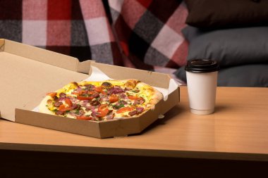 Eritilmiş peynirli, domatesli ve ahşap bir masada jambonlu nefis bir pizza. Paket servis veya yemek seçenekleri için mükemmel.. 