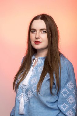 A close-up portrait of a woman wearing a light blue embroidered blouse. The traditional design and her composed look symbolize cultural pride and elegance. clipart