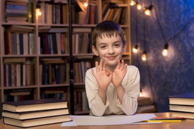 A child in a cozy library environment, sitting at a desk with books and stationery, illuminated by warm string lights. Great for themes of education, learning, and academic activities.  clipart