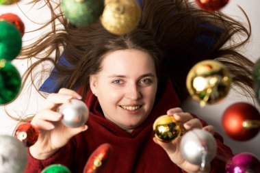 Renkli Noel süsleriyle çevrili bir kişinin yerde yattığı bayram sahnesi. Tatil temalı tasarımlar ve promosyonlar için mükemmel. Neşeli ve canlı tatil ruhları yakalamak için.